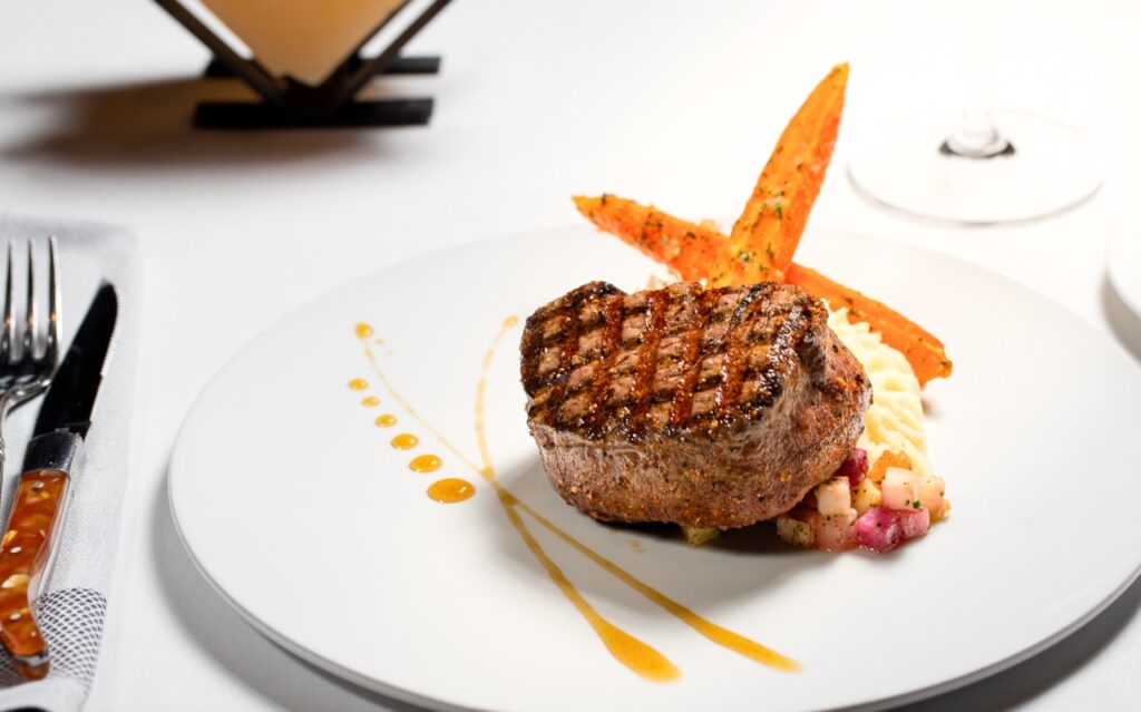 Filet mignon steak over potatoes purée in a fine dining restaurant.