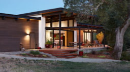 Klopf Architecture in Sacramento designed this single-story modern house with intense summer heat in mind, building a patio under the shade of a mature oak with a large overhang.