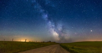 the milky way rises over a dirt road in Kamloops, British Columbia