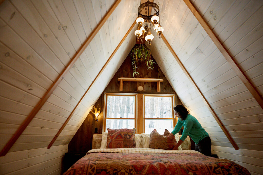 Airbnb Host Making Bed Winter Cabin