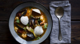 Bowl of cioppino with napkin and spoon