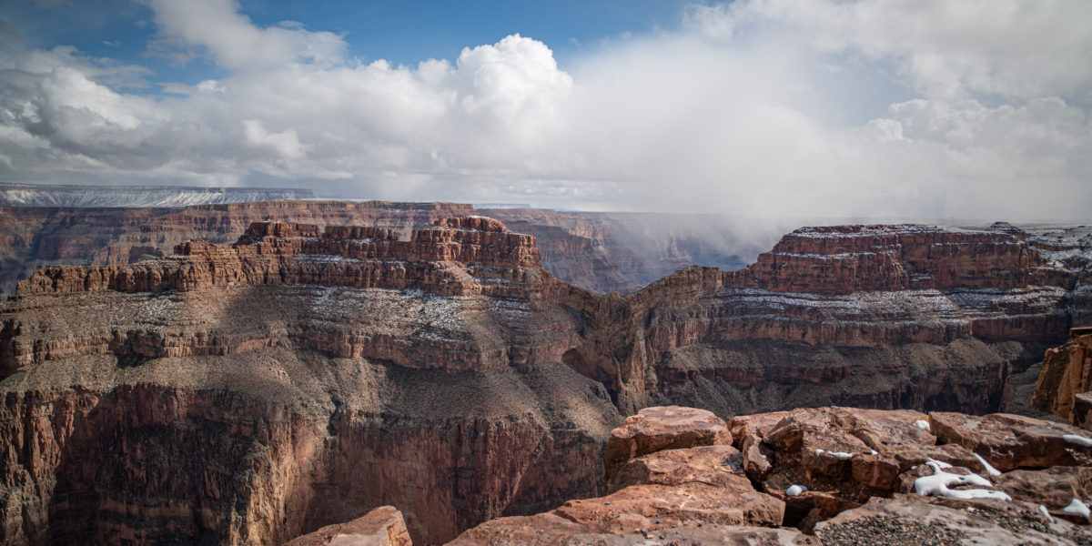 Steep drop into Grand Canyon with snow storms moving in in the distance