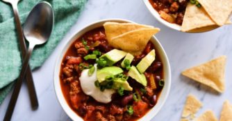 Mom's Chili by Dustin Harder shown on marble background with chips and other ingredients.