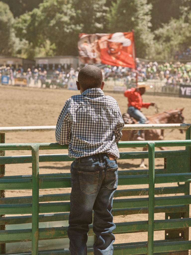 Young cowboy watches Bill Pickett Rodeo