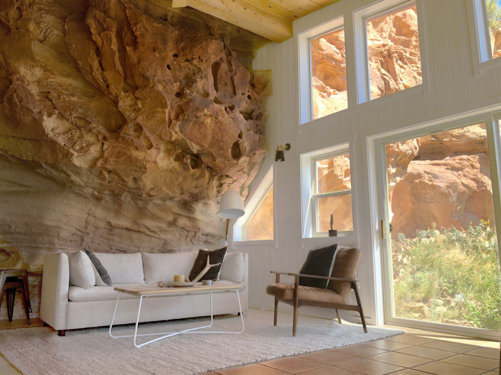 couch and chair living room set with with tall ceiling and window inside cave