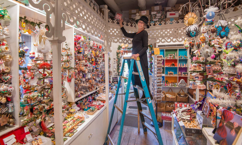 susan weber on ladder in susan's christmas shop