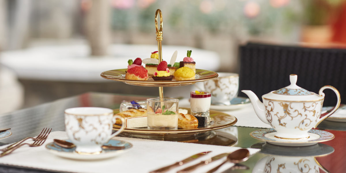 A tray of pastries, teapot, cup, and saucer