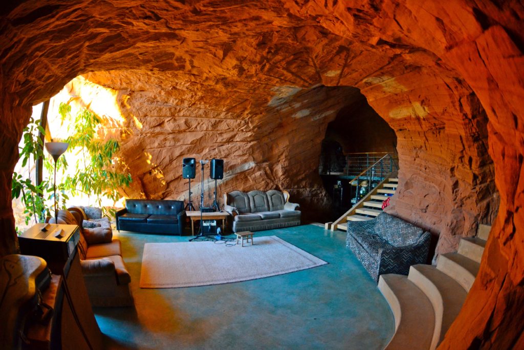 couches and chairs sit in cave room with rock walls around