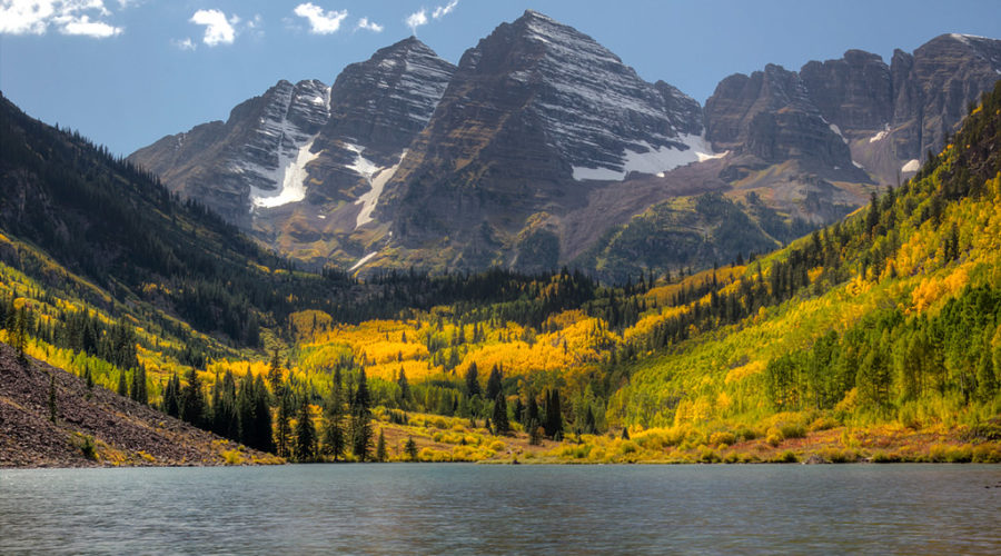 Maroon Bells, seen in front of a lake and with a snow-capped peak, is one of the best places in the country for fall color,