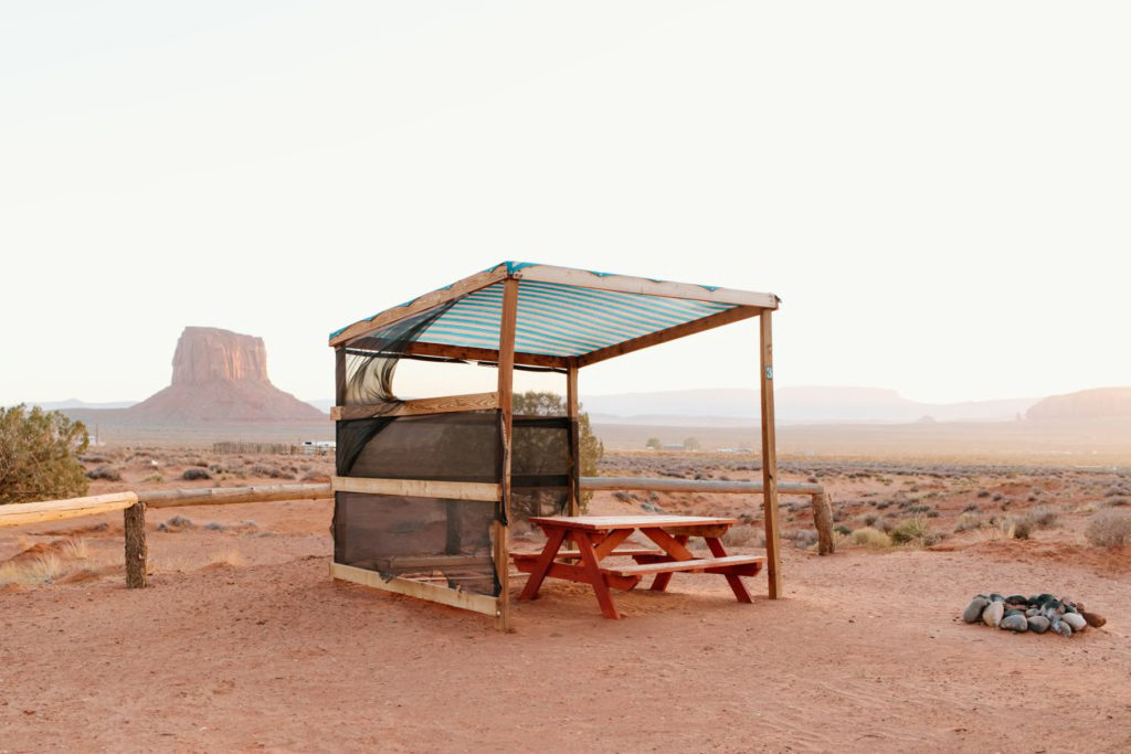 picnic table with desert and towering rock formation in the distance