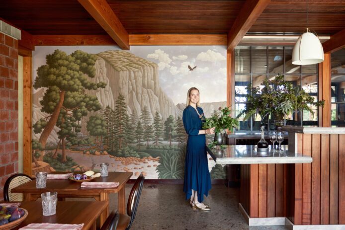 The interior of a winery, featuring a mural of a forest landscape