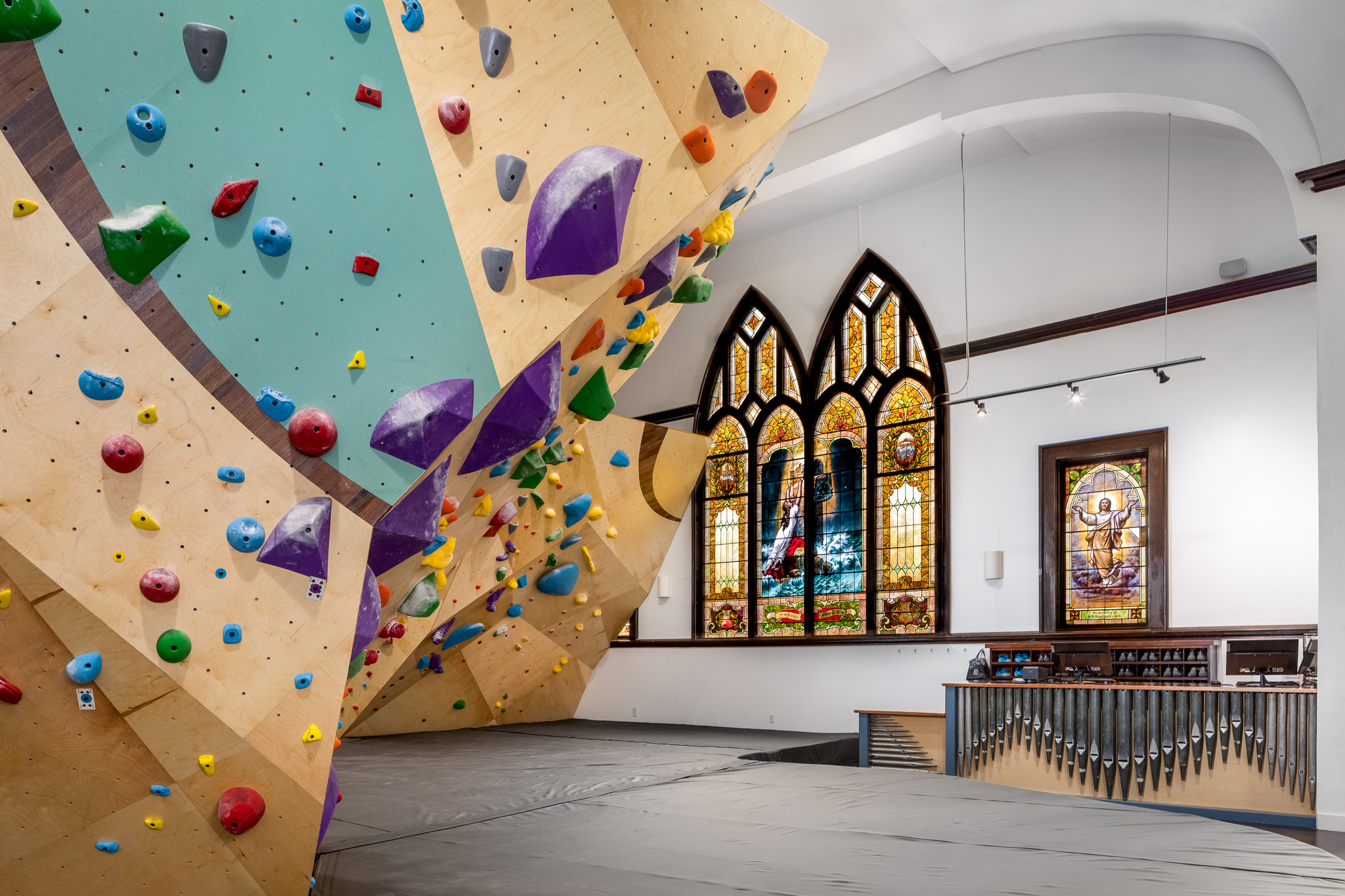 Climbing walls against the backdrop of a stained glass window.