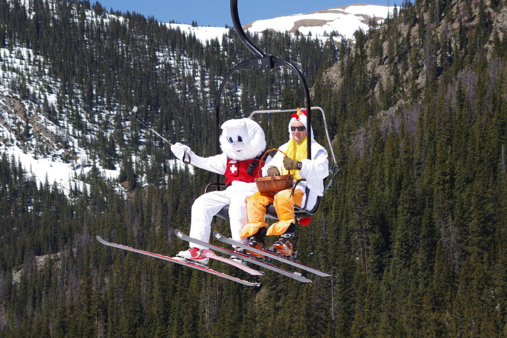 Skiers in chicken and bunny costume riding life at Arapahoe Basin