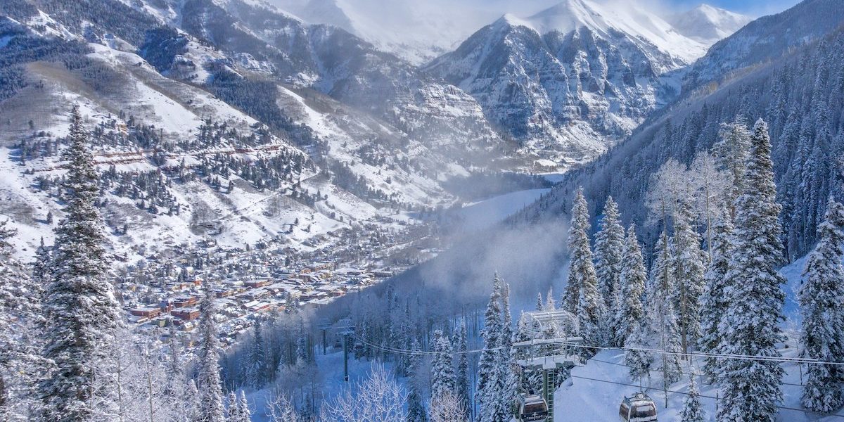 Aerial view of Telluride lifts in winter with peaks in background