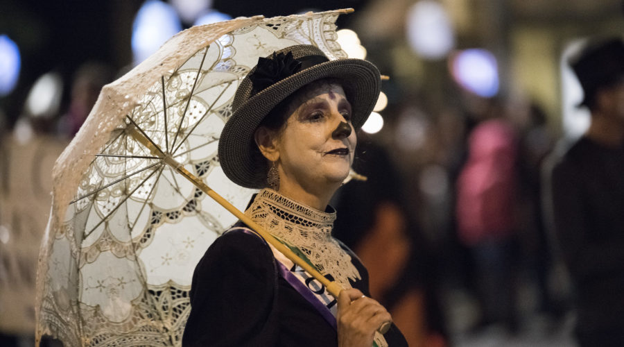 Woman in costume with Day of the Dead makeup and Victorian costume and lace umbrella