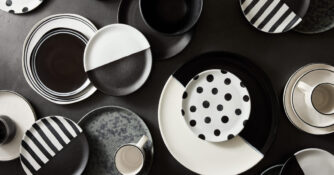 A collection of black and white dishes and mugs.