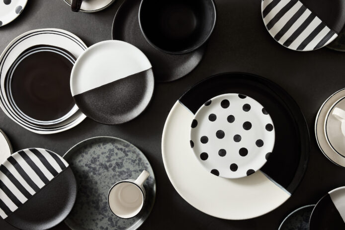 A collection of black and white dishes and mugs.