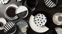 A collection of black and white dishes and mugs.