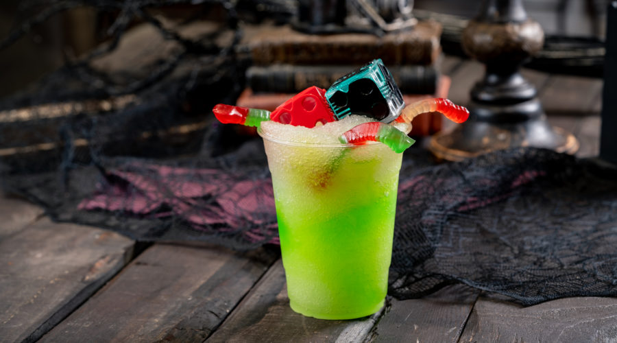 Green slushie with gummy worms and novelty oogie boogie dice