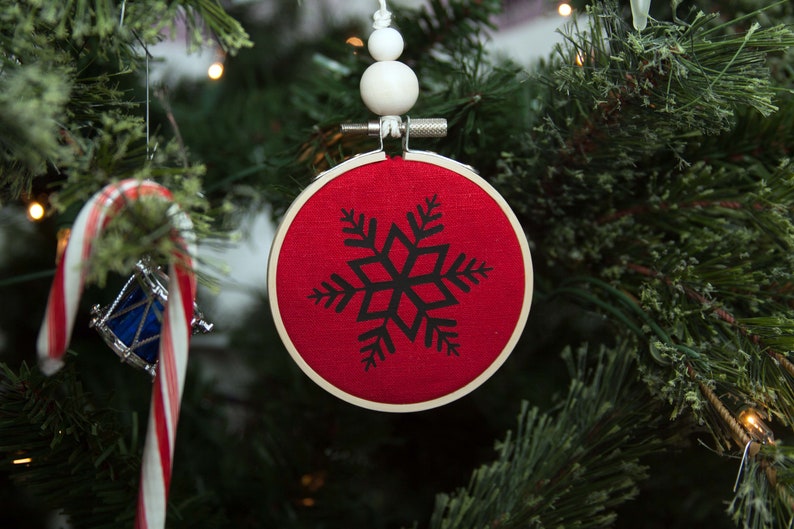 embroidery hoop red field with black snowflake in tree