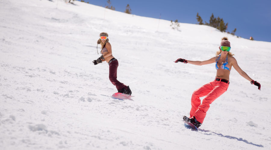 Two women skiing in bikini tops and ski pants at Mammoth Mountain