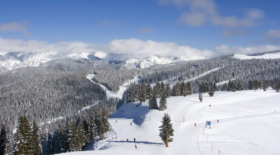 Skiers at Vail under a blue sky