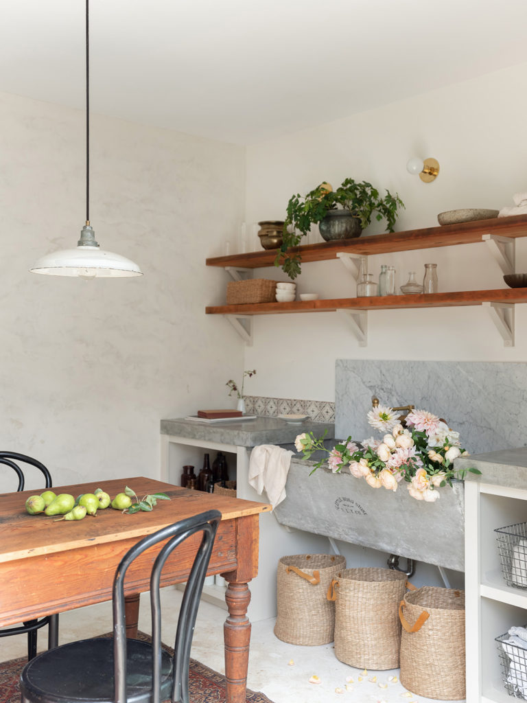 Teressa Johnson Floral Studio kitchen with table, sink, and floating shelves