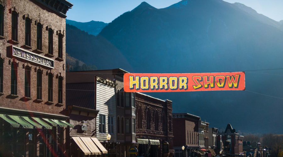 Downtown view of Telluride with a sign that advertises the town's haunted houses