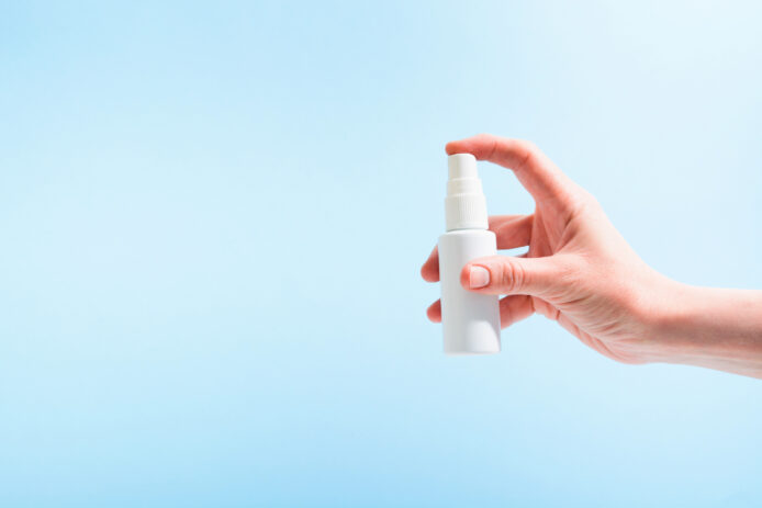 Hand holding spray bottle