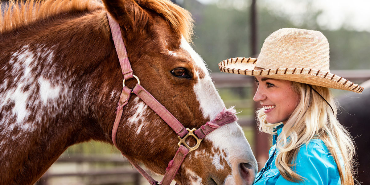 Devon Combs in a Cowboy Hat with a Horse