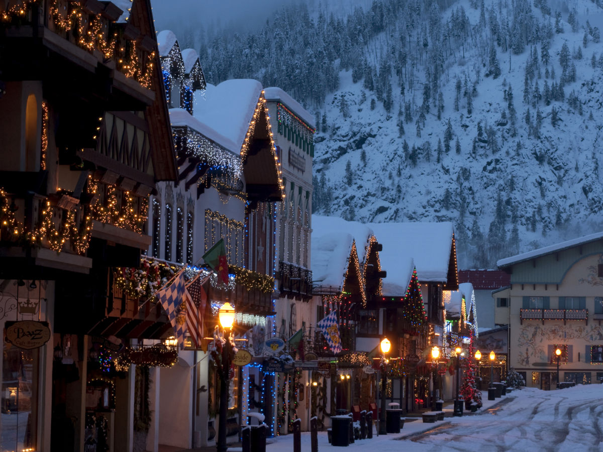 Holiday lights in downtown Leavenworth, Washington at dusk with snow