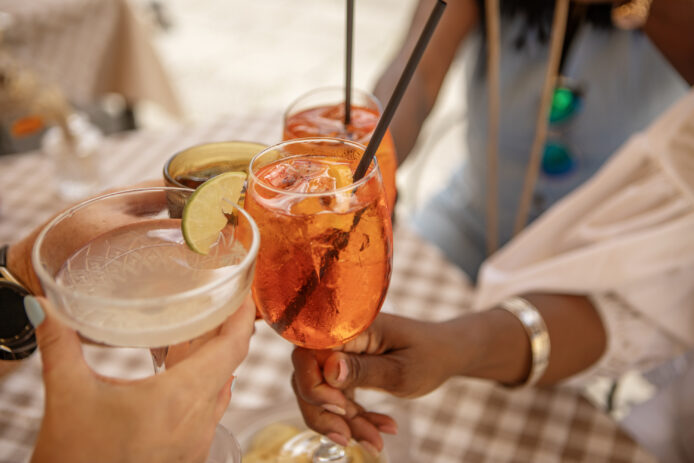 People toasting with different mocktails in hand.