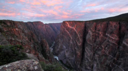Sun rises over the Painted Wall cliff at Black Canyon of the Gunnison, Colorado, a great alternative to Grand Canyon, which is affected by overtourism