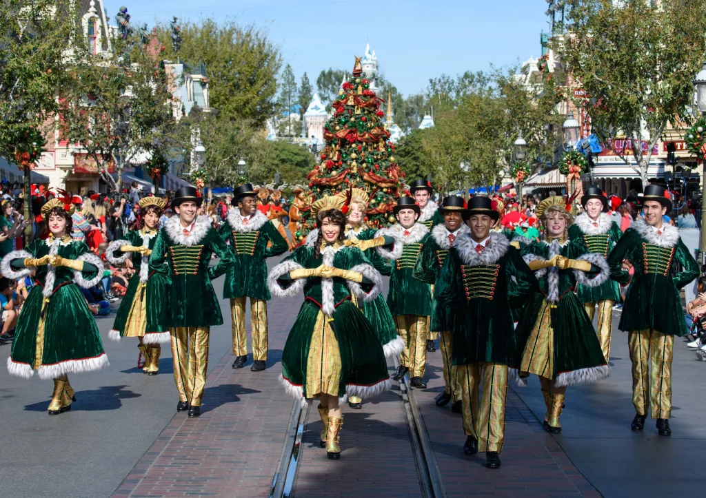 members of parade marching in front of christmas tree