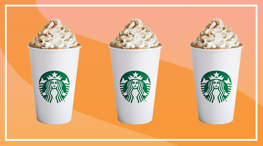 A Starbucks-branded cup filled with pumpkin spice latte and topped with whipped cream