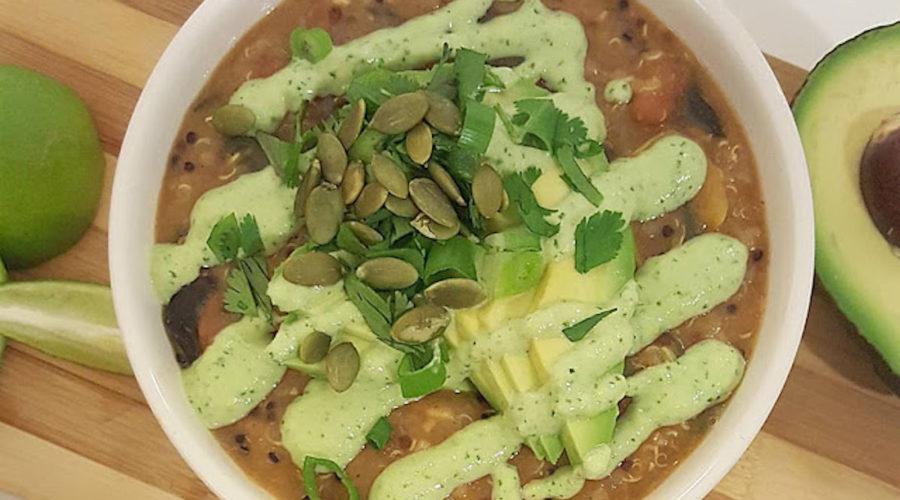 Quinoa Chili for the People by Joni Newman from Just the Food, shown on wooden table with avocados.