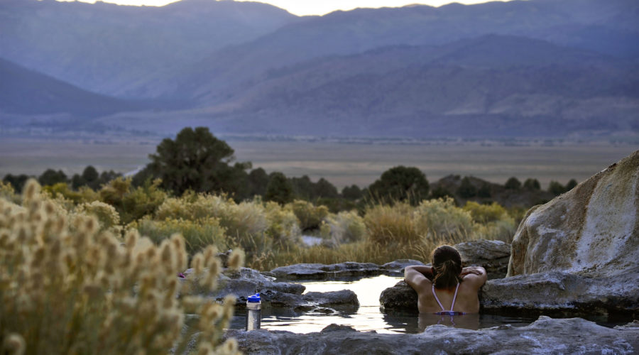 Woman soaking in a hot spring in the lower pool at Travertine Hot Springs in the California Sierra Nevada