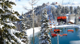 The ski gondolas at Park City Mountain surrounded by snowy slopes and trees during the day