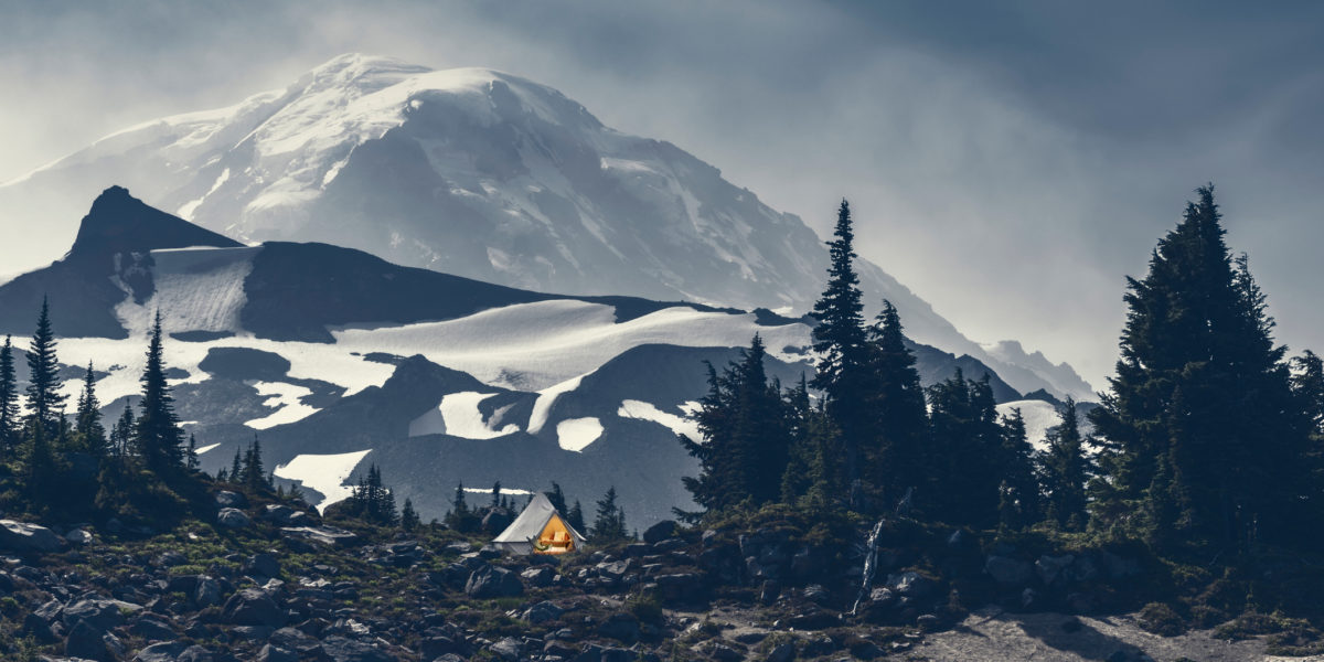 A campsite on a rocky flat area at Mount Rainier with grey skies overhead
