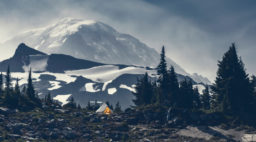A campsite on a rocky flat area at Mount Rainier with grey skies overhead
