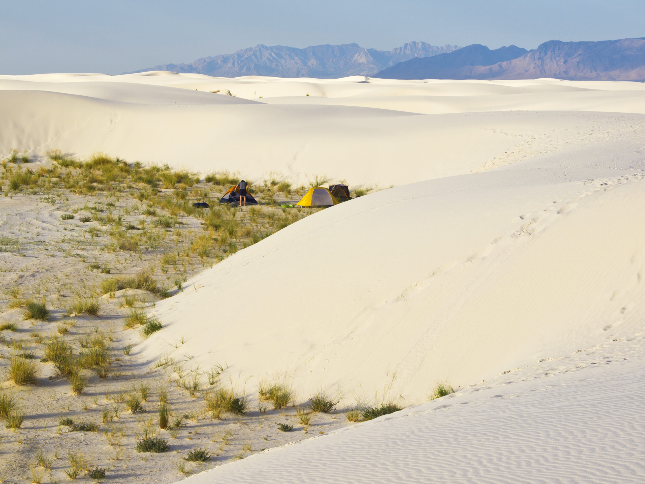 Morning on camp among sand dunes with blue sky above at White Sands National Monumen