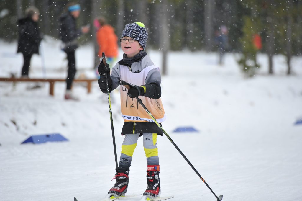 Little kid cross country skiing in snow in West Yellowstone