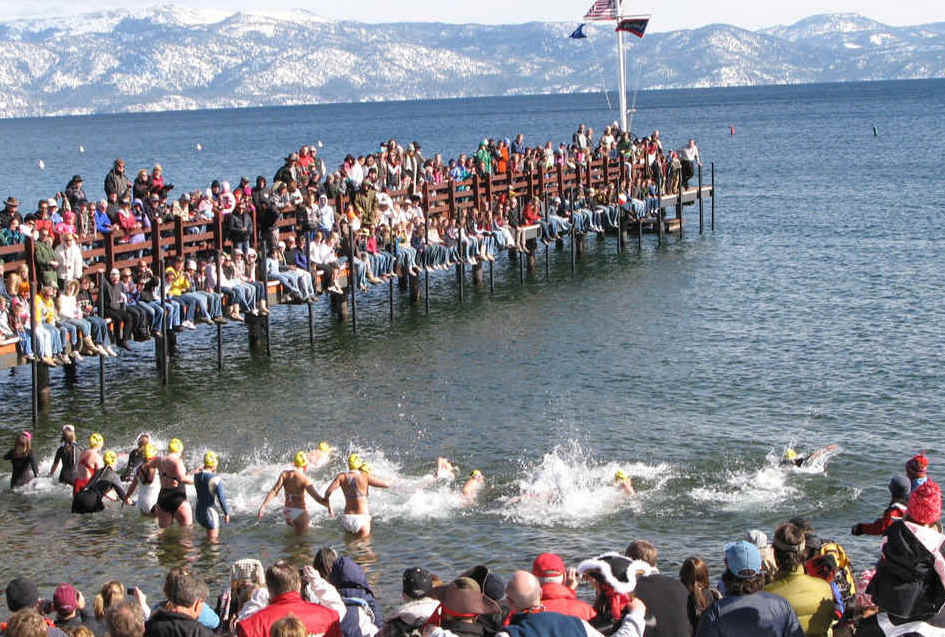 People standing on a dock in Lake Tahoe as swimmers take a polar plunge