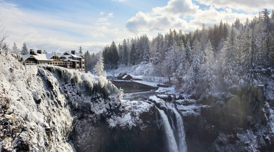 Salish Lodge surrounded by snow with the waterfall in winter
